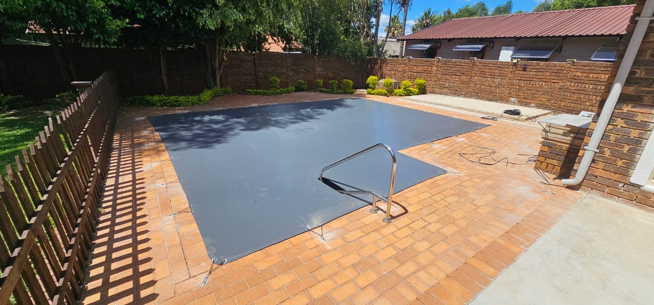 Charcoal pool cover fitted around a built-in handrail