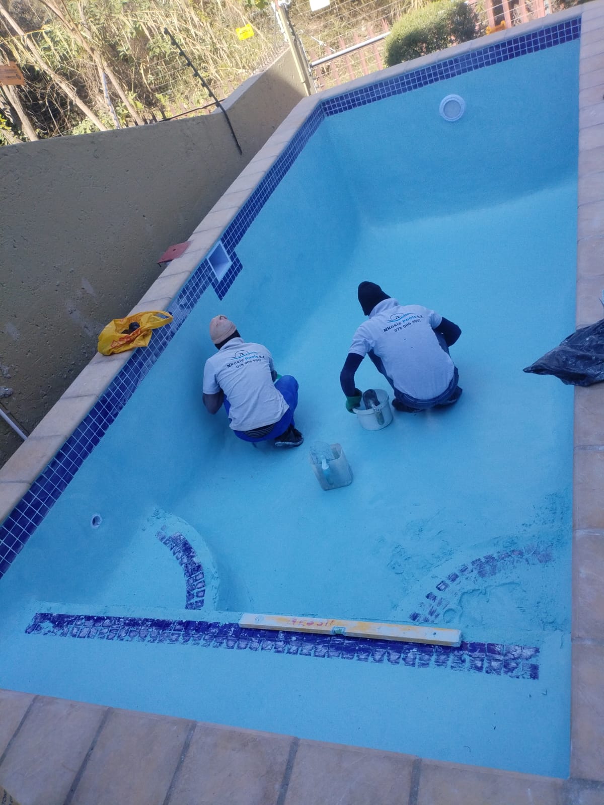 Team applying marbelite finish inside a pool